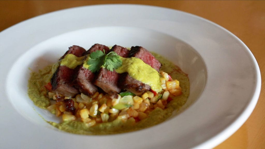 Sous Vide N.Y. strip over Sesame Corn Maque Choux with Roasted Corn Cilantro Sauce
